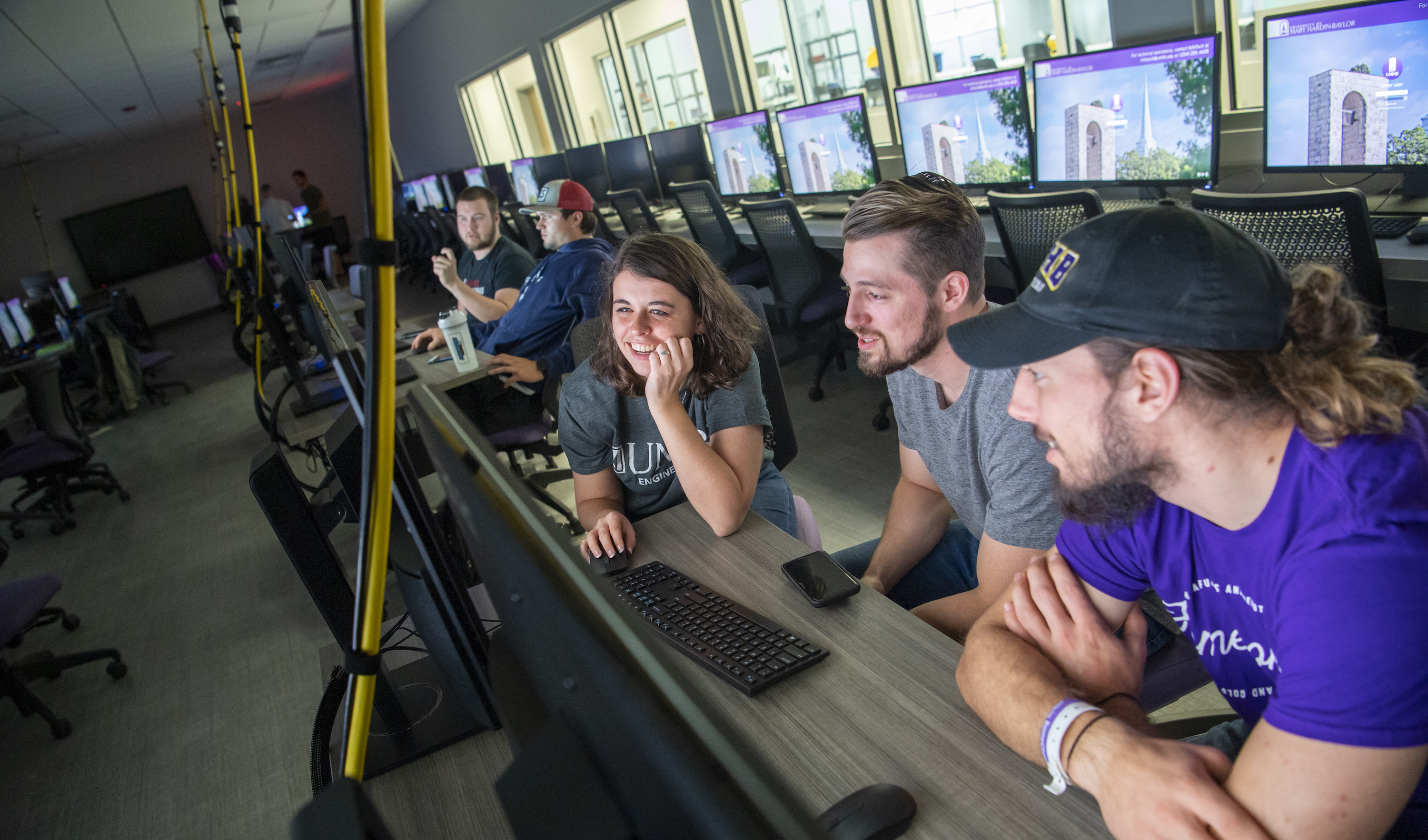 UMHB students looking at a computer screen in a computer lab