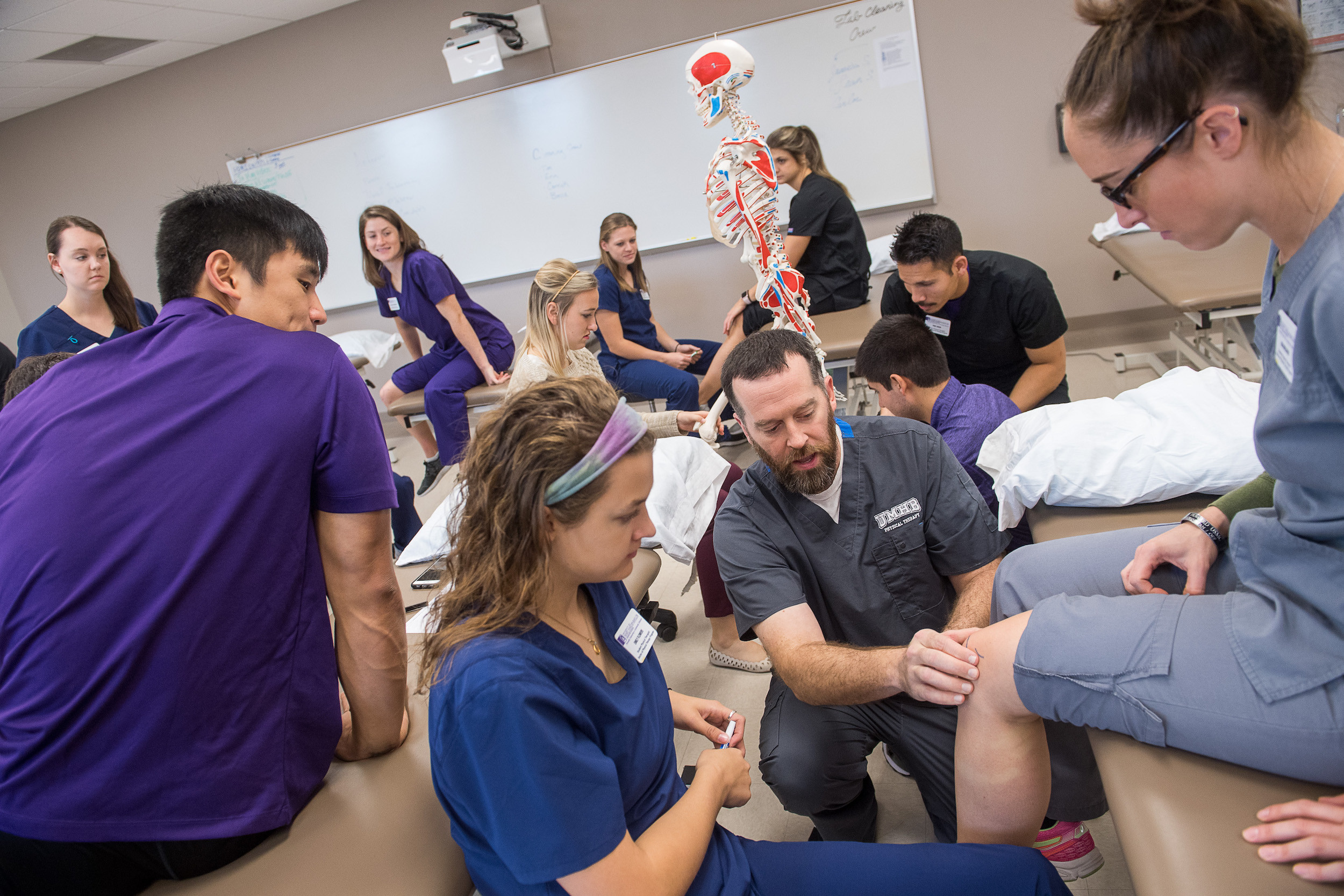 UMHB instructer showing students something with a knee on a patient